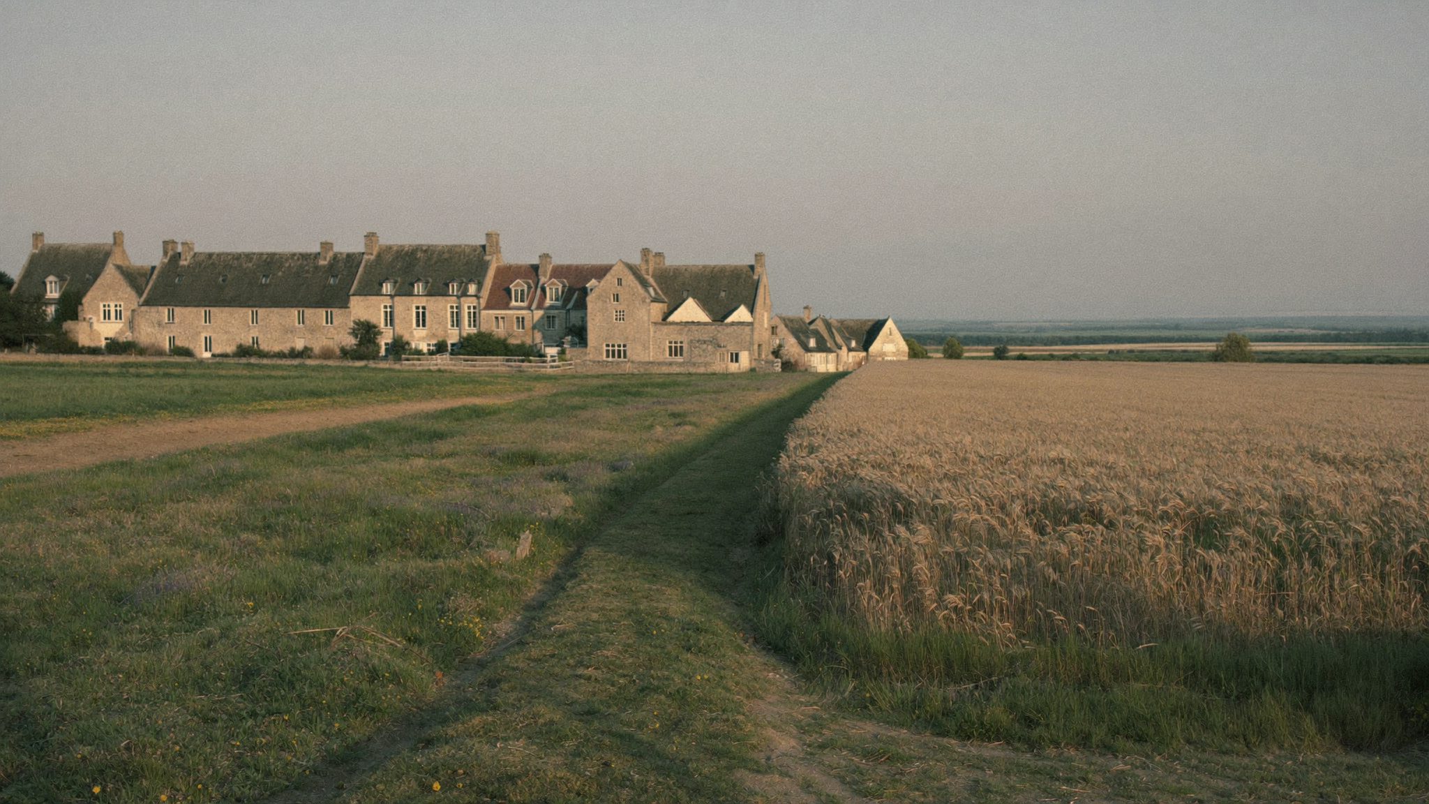 Maisons de pierre en orée de village, champs ouverts aux alentours